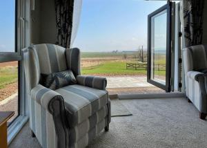 a living room with a chair and a sliding glass door at Royal Arch Park in Fettercairn