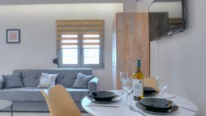 a living room with a table and a couch at Loutsiana Apartments Corfu in Alykes Potamou