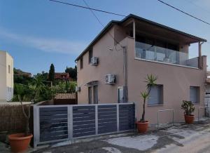 a house with a blue fence in front of it at Loutsiana Apartments Corfu in Alykes Potamou