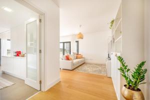 ein Wohnzimmer mit weißen Wänden und einem weißen Sofa in der Unterkunft GuestReady - Tranquil Seixal Haven in Seixal