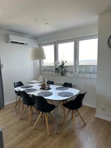 a white dining room with a table and chairs at Prestige Aquapark Apartments - Aquatower in Reda