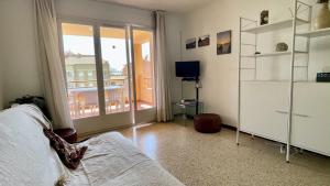 Zimmer mit einem Bett, einem TV und einem Balkon in der Unterkunft JORA 3A - apartamento in L'Estartit