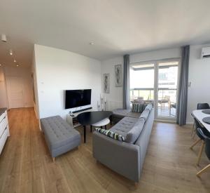 sala de estar con sofá, mesa y TV en Prestige Aquapark Apartments - Aquatower en Reda