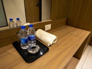 a tray with bottles of water on a counter at Hotel The UBE Residency in Mumbai