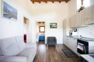 Montecchia di CrosaraにあるCasa Oliverのリビングルーム(白いソファ付)、キッチンが備わります。