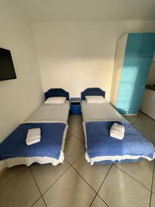 two beds in a room with blue cabinets at Prijevor Apartments in Budva