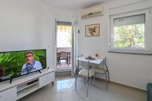 uma sala de estar com uma televisão, uma mesa e uma sala de jantar em LaLee em Novalja