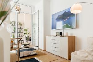 a living room with a white cabinet and a table at Luxuswohnung im Herzen Potsdams! in Potsdam