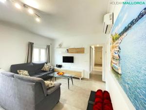 een woonkamer met een bank en een tv bij Lakeside Plaza - Alcúdia Beach in Alcudia