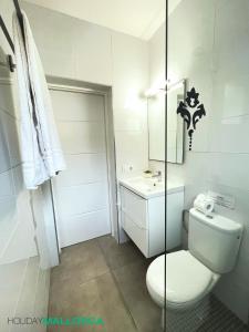 een witte badkamer met een toilet en een wastafel bij Lakeside Plaza - Alcúdia Beach in Alcudia