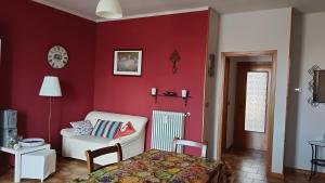 a bedroom with a red wall with a chair and a bed at Appartamento Laura in Quargnento