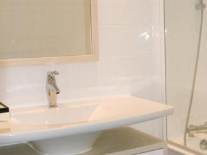 a white bathroom with a sink and a shower at Short Stay Paris Apartments in Paris