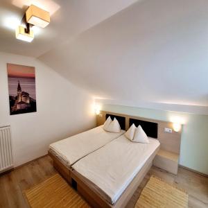1 dormitorio con 1 cama grande con sábanas blancas en Penzion Gostisce Lesjak en Orehova vas 