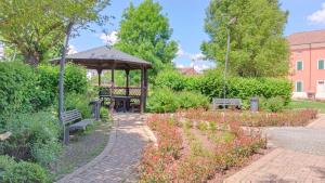 a gazebo with two benches in a garden at Appartamento Laura in Quargnento