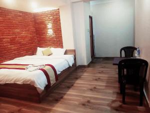 - une chambre avec un grand lit et un mur en briques dans l'établissement Hotel Highway 75, à Benighāt