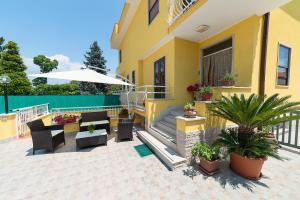 a house with a patio with a table and chairs at Il Melograno da Pina in Borgo Grappa