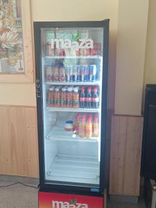 a refrigerator filled with lots of sodas and drinks at Great Himalayan Nature View Resort in Banjār