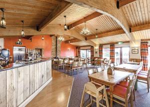 een restaurant met houten tafels en stoelen en een bar bij Bucklegrove Holiday Park in Rodney Stoke