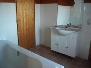 baño con lavabo, espejo y puerta en Ferienhaus Fernblick mit Terrasse, Garten und Grill, en Windeck