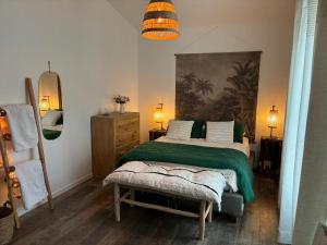 - une chambre avec un grand lit et une couverture verte dans l'établissement Maison en lisière de forêt, à Bois-le-Roi