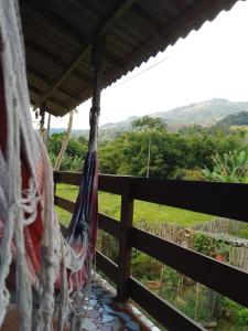 a hammock on a fence with a view of a field at Rancho Pé da Pedra in São Bento do Sapucaí