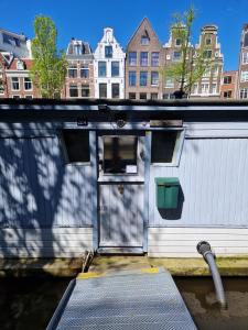 een gebouw met een deur en een oprit in het water bij Pantheos Top Houseboat in Amsterdam