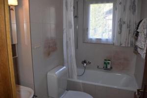 uma casa de banho com um WC, uma banheira e um lavatório. em Haus Ahorni, ruhige 1 Zi-Wohnung, Wi-Fi, Aussicht, - b48579 em Beatenberg