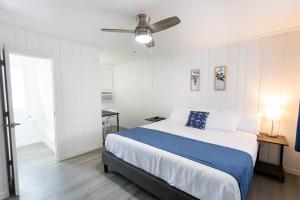Anchor Bay Inn and Suites في ساندسكاي: غرفة نوم بسرير ومروحة سقف
