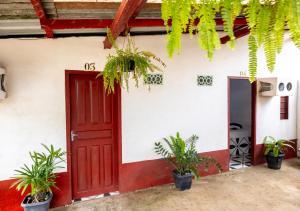 a red door of a house with potted plants at Pousada Paraíso in Novo Airão