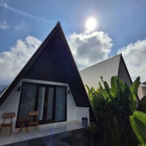 a house with a black and white roof at Volcano White Glamping in Kubupenlokan