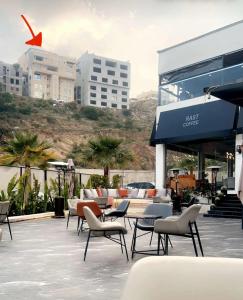 een patio met stoelen en tafels voor een gebouw bij شقة خمس غرف علي طريق السودة in Abha