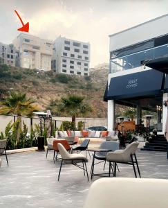 a patio with chairs and tables in front of a building at شقة خمس غرف مطلة على طريق السودة in Abha