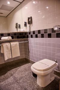 een badkamer met een toilet en een telefoon aan de muur bij South American Copacabana Hotel in Rio de Janeiro