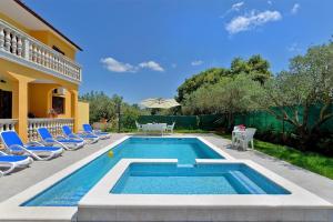 uma piscina com cadeiras e uma casa em Ferienhaus mit Privatpool für 16 Personen ca 190 qm in Vodnjan, Istrien Istrische Riviera em Vodnjan
