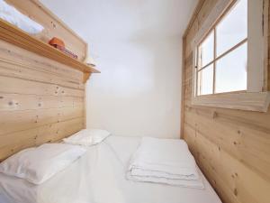 um pequeno quarto com uma cama e uma janela em APPARTEMENT PIED DES PISTES - SAINT JEAN D'AULPS STATION - 4 Personnes - RELAIS S36 em Saint-Jean-dʼAulps