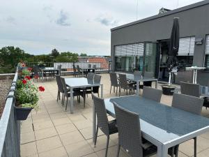 a patio with tables and chairs on a building at Hotel Efcannos Dornberg Carree in Vechelde