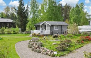 a garden in front of a small house at Lovely Home In Hammar With Lake View in Hammarö