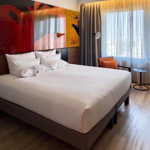 a bedroom with a large white bed in a room at Novotel Santiago Providencia in Santiago