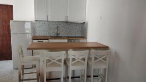 eine Küche mit einem Holztisch und weißen Schränken in der Unterkunft Studio für 4 Personen ca 40 qm in Njivice, Kvarner Bucht Krk - b58757 in Njivice