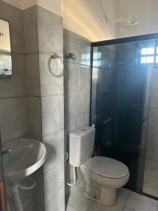 a bathroom with a toilet and a sink and a shower at Residencial Castelinho in Mucuri