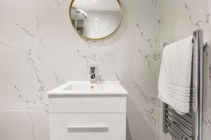 a bathroom with a white sink and a mirror at Marylebone City Apartments in London
