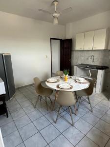a kitchen with a table and chairs in a room at Apartamentos completos no centro - vista mar in Mucuri +10 photos