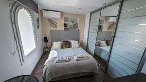een slaapkamer met een bed en een grote spiegel bij Le Mas d'Angeline in Beausoleil