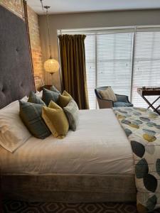 um quarto com uma cama grande com almofadas em Rooms at number one em Broadstairs