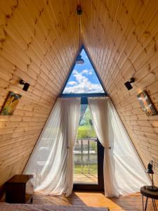 una camera con una grande finestra in una casa di legno di Kuro cottage- A frame a Kazbegi