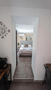 een slaapkamer met een bed in een witte kamer bij Le Mas d'Angeline in Beausoleil