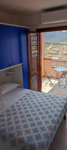 a bedroom with a bed and a table and a balcony at La Perla nel Blu in Villasimius