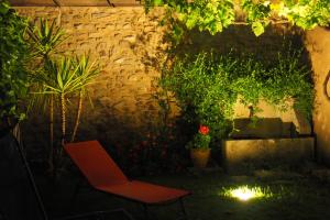un giardino con sedia e piante di notte di Chambres d'Hôtes Le relais des marmottes a Lagnes