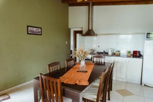 a dining room with a table and a kitchen at Cabañas "El Valle" in San Rafael