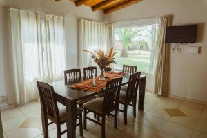 a dining room with a wooden table and chairs at Cabañas "El Valle" in San Rafael